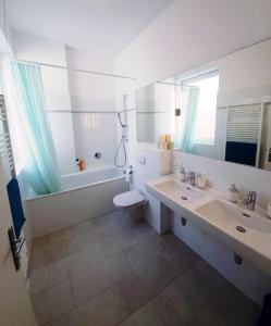 ein Badezimmer mit einem Waschbecken, einem WC und einem Spiegel in der Unterkunft Art of Simmering in Wien