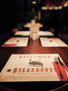 een tafel met een restaurantbord erop bij Roastineer Hotel in Battenberg