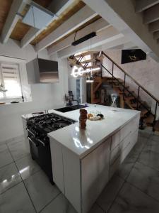 a large kitchen with a stove and a staircase at CHEZ COCO in Roquefort-de-Sault