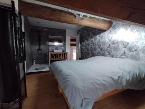 ein Schlafzimmer mit einem großen weißen Bett in einem Zimmer in der Unterkunft CHEZ COCO in Roquefort-de-Sault