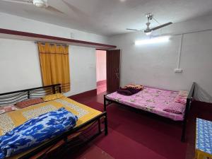 Cette chambre comprend 2 lits et une fenêtre. dans l'établissement SHANTINIR HOMESTAy, à Santiniketan