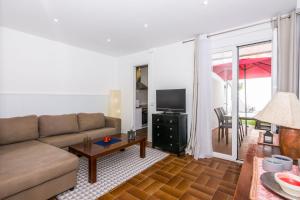a living room with a couch and a television at HomeHolidaysRentals Arlene in Calella