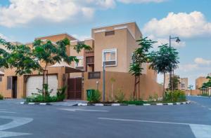 a building with a parking lot in front of it at Villa in Al Madinah in compound فيلا في المدينة in Al Madinah