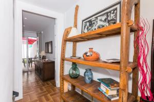 Pokój z drewnianymi półkami z wazami i książkami w obiekcie HomeHolidaysRentals Arlene w mieście Calella
