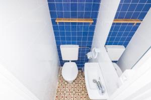 La salle de bains est pourvue de carrelage bleu, de toilettes et d'un lavabo. dans l'établissement HomeHolidaysRentals Arlene, à Calella