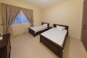 a hotel room with two beds and a window at Villa in Al Madinah in compound فيلا في المدينة in Al Madinah