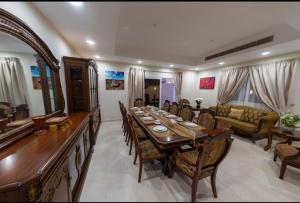 a dining room with a long table and chairs at Villa in Al Madinah in compound فيلا في المدينة in Al Madinah