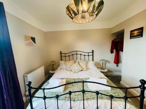 a bedroom with a bed and a chandelier at NEW homely countryside escape in Manningtree