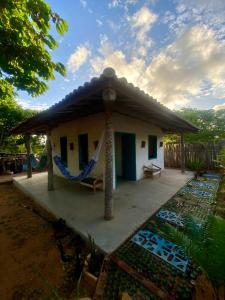 a small house with a hammock in front of it at Restaurante e Repousares do Nildo in Icapuí