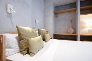 Un dormitorio con una cama con sábanas y almohadas blancas. en Trinità UrbanHaven - Cuore di Cagliari, en Cagliari
