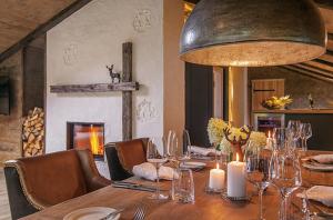 a dining room with a long wooden table with candles at Boutique Hotel Relais Chalet Wilhelmy in Bad Wiessee