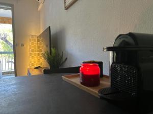 une bougie assise sur un plateau en bois à côté d'une table dans l'établissement Appartement Résidence Santa Barbara avec Piscine et à 750m de la Plage, à Cavalaire-sur-Mer