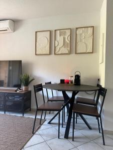 - une salle à manger avec une table et quatre chaises dans l'établissement Appartement Résidence Santa Barbara avec Piscine et à 750m de la Plage, à Cavalaire-sur-Mer