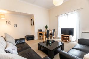 a living room with a couch and a table at April Disc - Long Stay - Contractors in Swindon