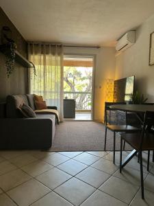 uma sala de estar com um sofá e uma mesa em Appartement Résidence Santa Barbara avec Piscine et à 750m de la Plage em Cavalaire-sur-Mer