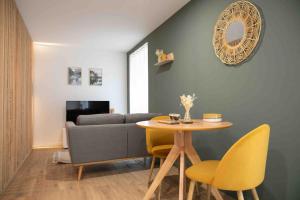 a living room with a table and a couch at Studio cosy, neuf, hyper centre in Brantôme