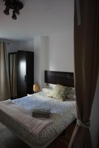 una camera con letto e testiera nera di Apartamento en Huelva. a Huelva