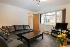 a living room with a couch and a coffee table at 2A Kent Cottages in Reading