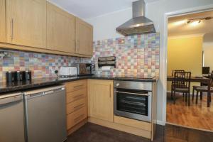 a kitchen with stainless steel appliances and a table at 2A Kent Cottages in Reading