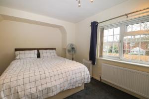 a bedroom with a bed and a window at 2A Kent Cottages in Reading