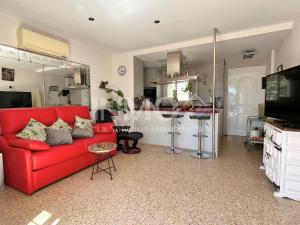 een woonkamer met een rode bank en een keuken bij Casa con gran jardín y jacuzzi en La Llosa 108D - INMO22 in Cambrils