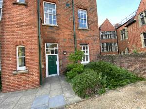 an empty brick building with a green door at Luxury 2BR apartment & parking central Winchester in Winchester