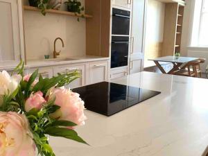 a kitchen with a counter top with flowers on it at Luxury 2BR apartment & parking central Winchester in Winchester +7 photos