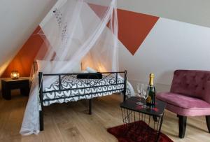 um quarto com uma cama, uma cadeira e uma mesa em Au coeur du vignoble/centre ville em Dorlisheim