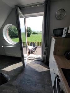 a kitchen with a door open to a patio with a table at Ferienwohnung 2 - a72142 in Wangerland