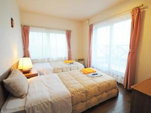 稚内市にあるペンション亜留芽利亜のベッドが2つと窓があるホテルの部屋