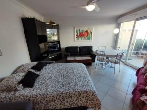 een slaapkamer met een bed en een woonkamer met een tafel bij Antibes T2 Vue mer 48m2 Terrasse Parking Piscine Plage in Antibes