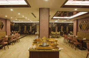 a restaurant with tables and chairs and a buffet in a room at Büke Hotel in Istanbul