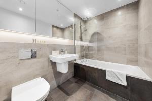 a bathroom with a toilet and a sink and a tub at SERCASA - Wembley Park - London in Preston