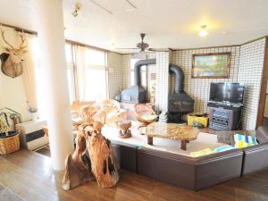a living room with a couch with a wood stove at Pension Arumeria in Wakkanai