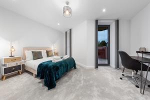 a bedroom with a bed and a desk and a chair at SERCASA - Wembley Park - London in Preston