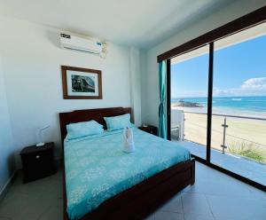 a bedroom with a bed with a view of the beach at Hotel Sierra Negra in Puerto Villamil