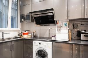 een keuken met een wasmachine en een wasmachine bij Spacious apartment with balcony in Parijs