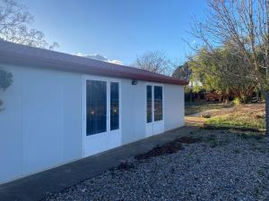 eine weiße Garage mit Glastüren an einem Haus in der Unterkunft La Geneta Casa Vacacional in Vilobi Del Penedes