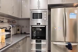 een keuken met een roestvrijstalen koelkast en een magnetron bij Spacious apartment with balcony in Parijs