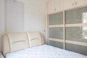 een slaapkamer met een wit bed en een glazen schuifdeur bij Spacious apartment with balcony in Parijs