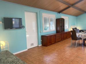 een woonkamer met een tafel en een tv aan de muur bij La Geneta Casa Vacacional in Vilobi Del Penedes