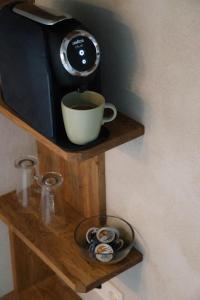 cafetera y una taza en una estantería de madera en Promenādes apartamenti, en Talsi
