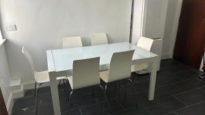 a white table and chairs in a room at Large 3 Bed Apt close to city, OVO Hydro and Ibrox Stadium in Glasgow