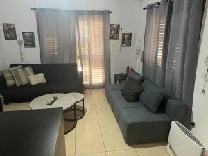 ein Wohnzimmer mit einem Sofa und einem Tisch in der Unterkunft Charalambous Apartment in Paphos City