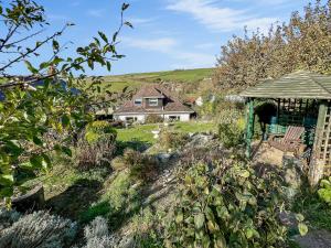 a garden with a house and a gazebo at Upalong in West Lulworth