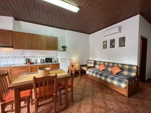 a kitchen and a living room with a couch and a table at Quinta Jardim das Palmeiras, T2 n 8 , Algoz in Silves
