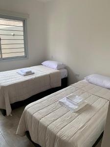 a room with two beds and a window at Housing center in Jesús María