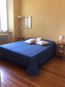 - un lit bleu avec deux oreillers dans une chambre dans l'établissement Alpi Giulie, à Intra