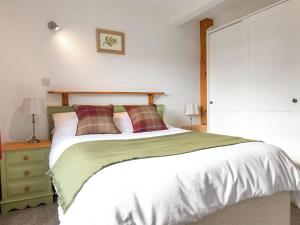 a bedroom with a large white bed with two pillows at Ash Cottage- Uk45892 in Farlam