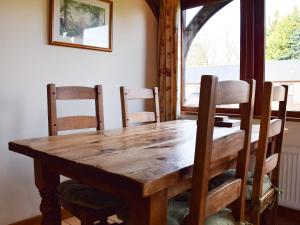 a wooden table and chairs in a room with a window at The Old Dairy - Meadowbrook Farm in Thame